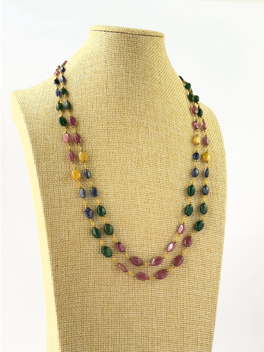 Layered necklace combining smooth oval ruby, sapphire, and emerald beads in adjustable 46–52cm lengths.