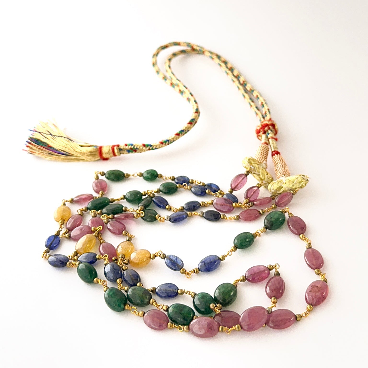 Elegant two‑strand gemstone necklace with smooth oval ruby, sapphire, and emerald beads.