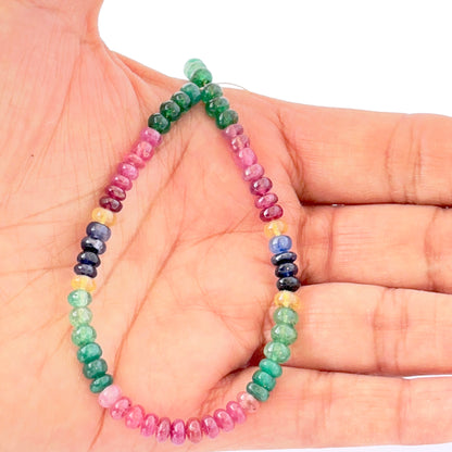 A person holds delicate strands of Multi Precious beads, showcasing their smooth design.