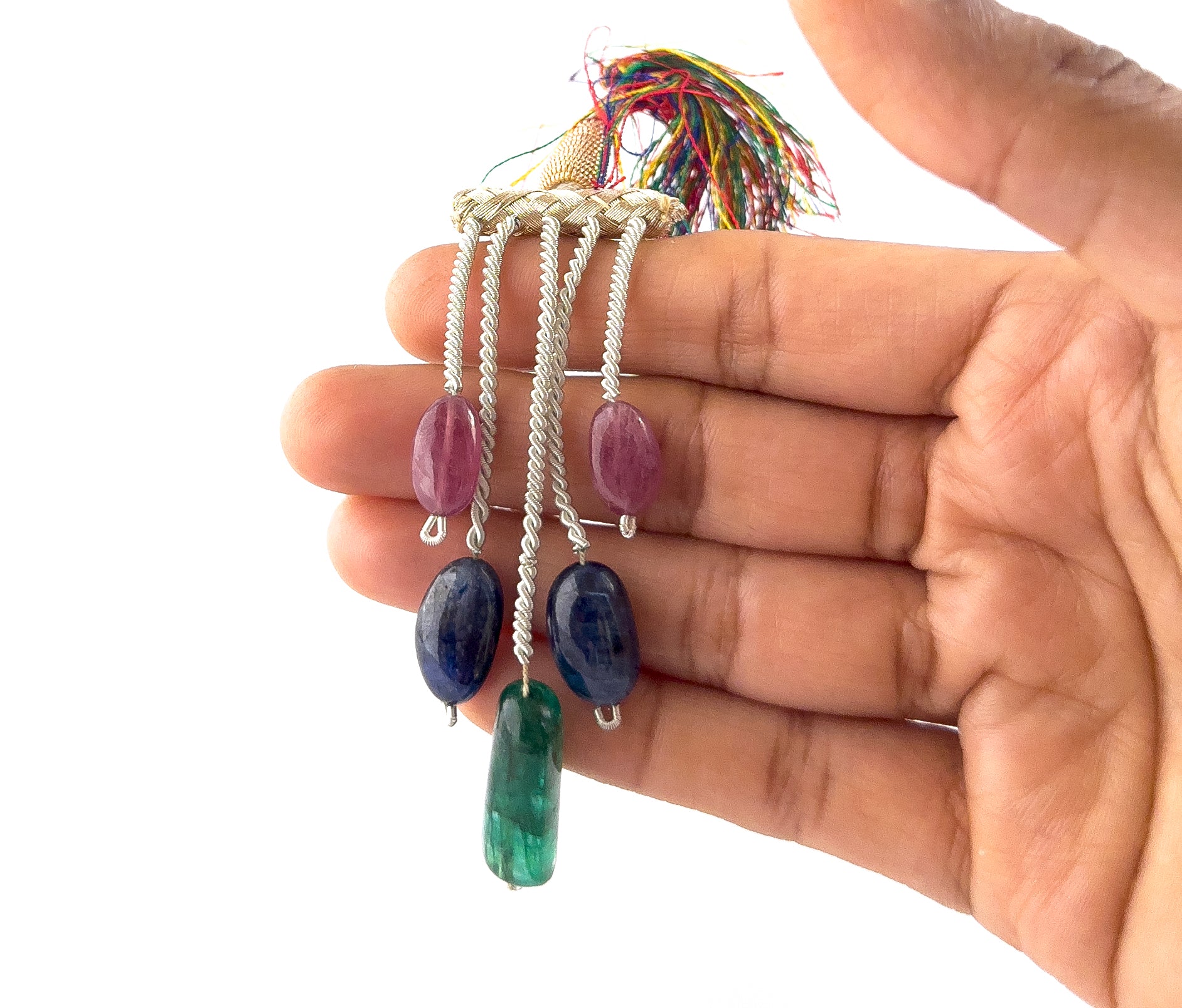 A person holds multi precious tumbled stones, showing their smooth finish and natural colour variation.