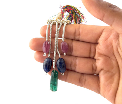 A person holds multi precious tumbled stones, showing their smooth finish and natural colour variation.