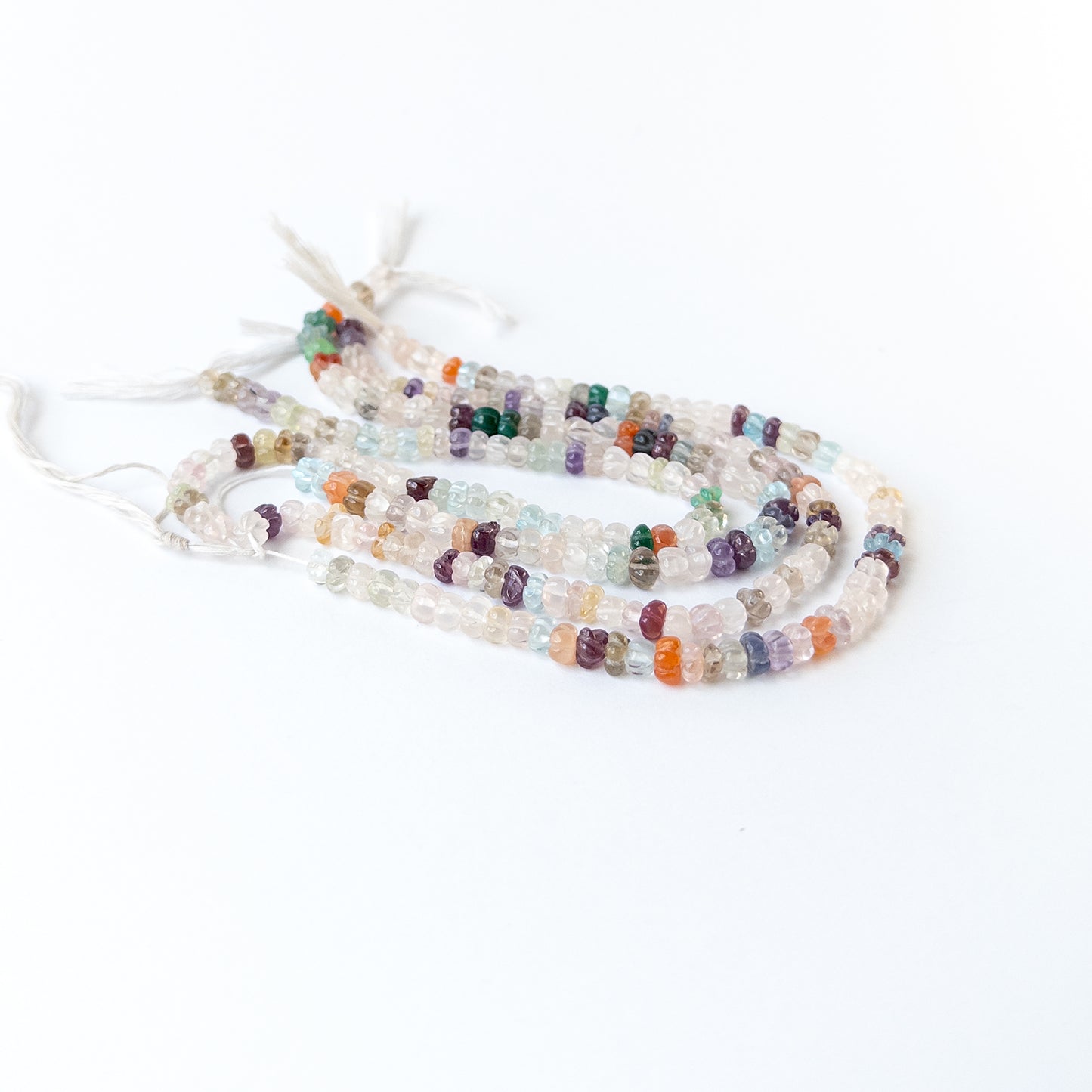 Close‑up of multi stone carved pumpkin beads showing detailed carving and natural gemstone shine.