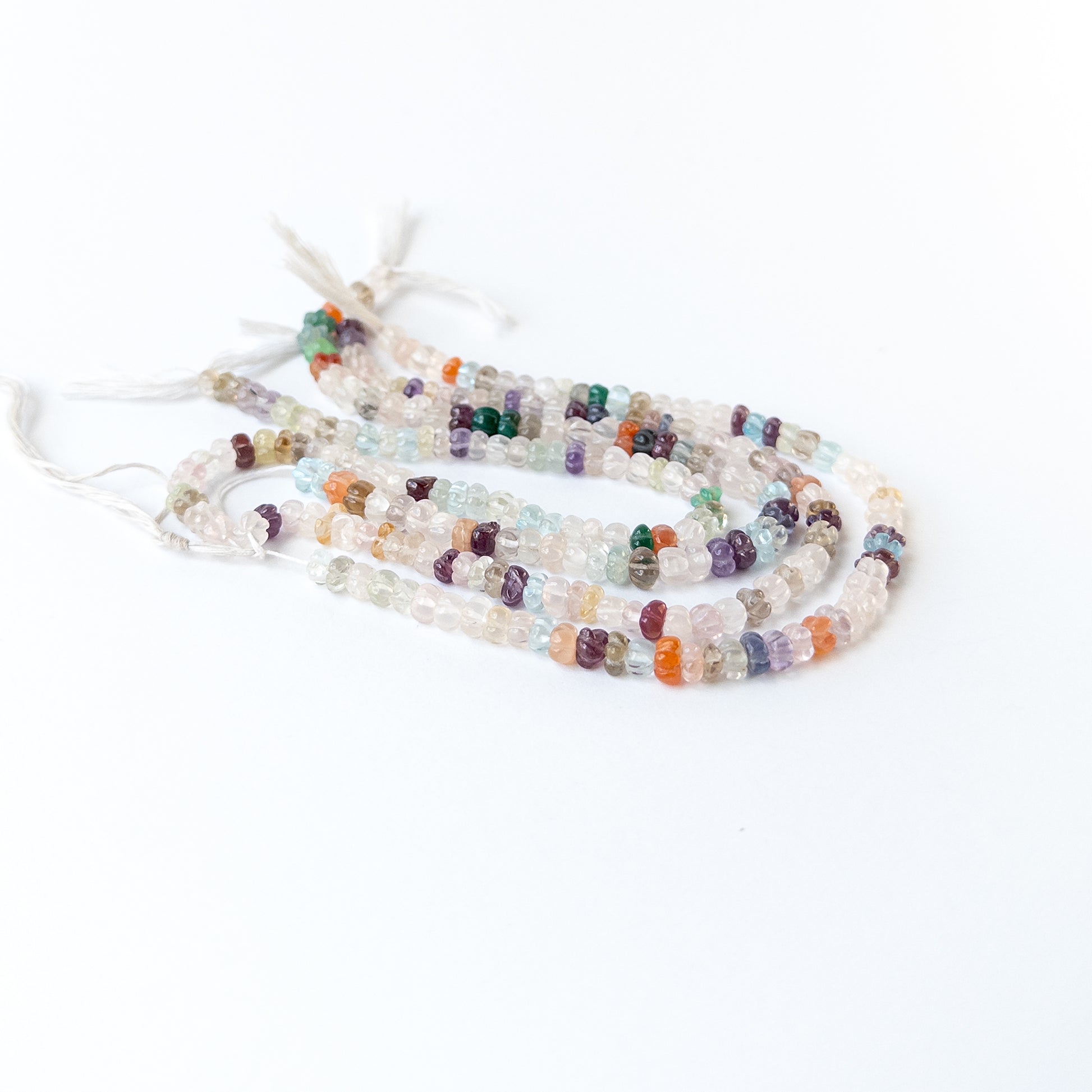 Close‑up of multi stone carved pumpkin beads showing detailed carving and natural gemstone shine.