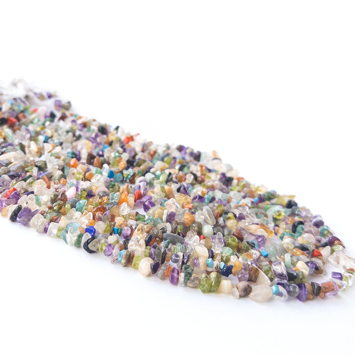 Handmade jewellery components featuring smooth multi‑stone chip beads in a neatly arranged strand.