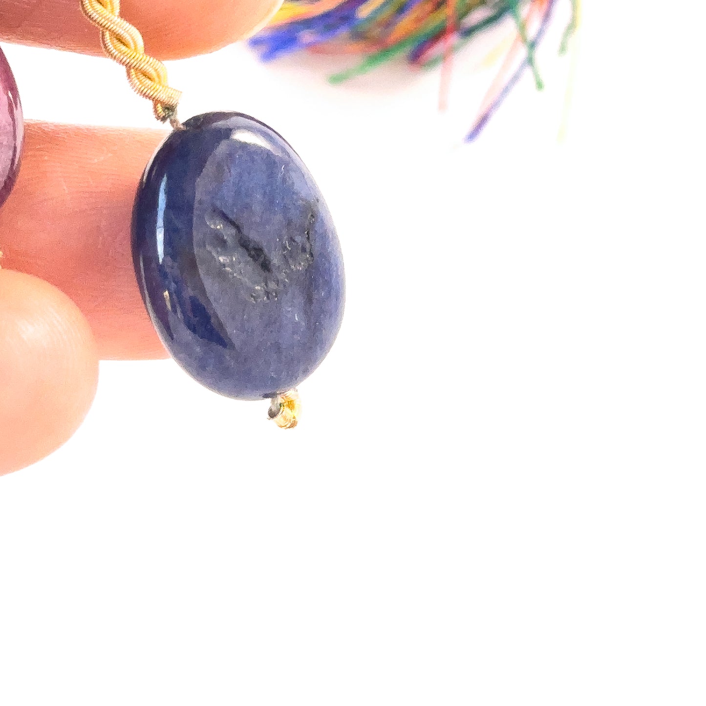 Smooth Oval Sapphire Bead in a person's hand