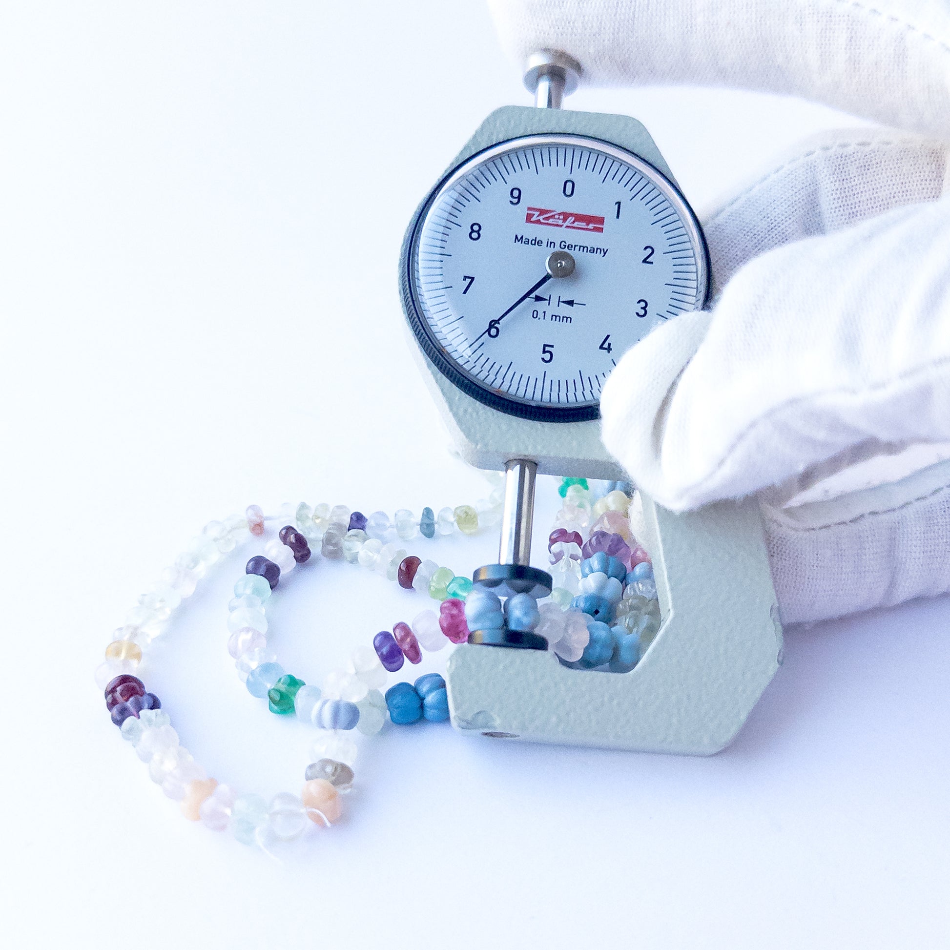 A dial gauge measures the multi‑stone pumpkin cut 4.5–7mm gemstone.