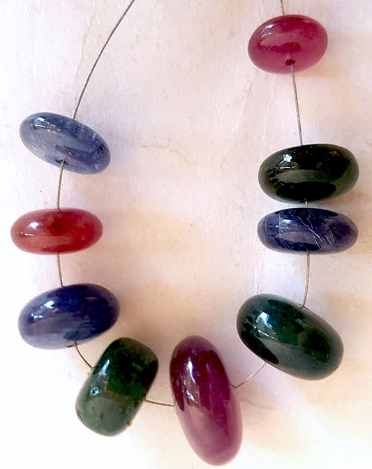 Blue sapphire, ruby, and emerald rondelle beads shine with smooth polish and rich colour across 82 carats.