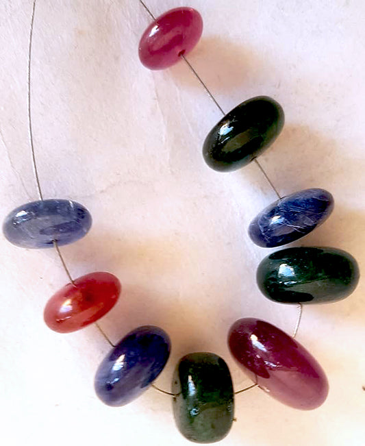 Close-up of multi stone smooth rondelle beads showing vibrant hues and glossy finish in a 9-piece set.
