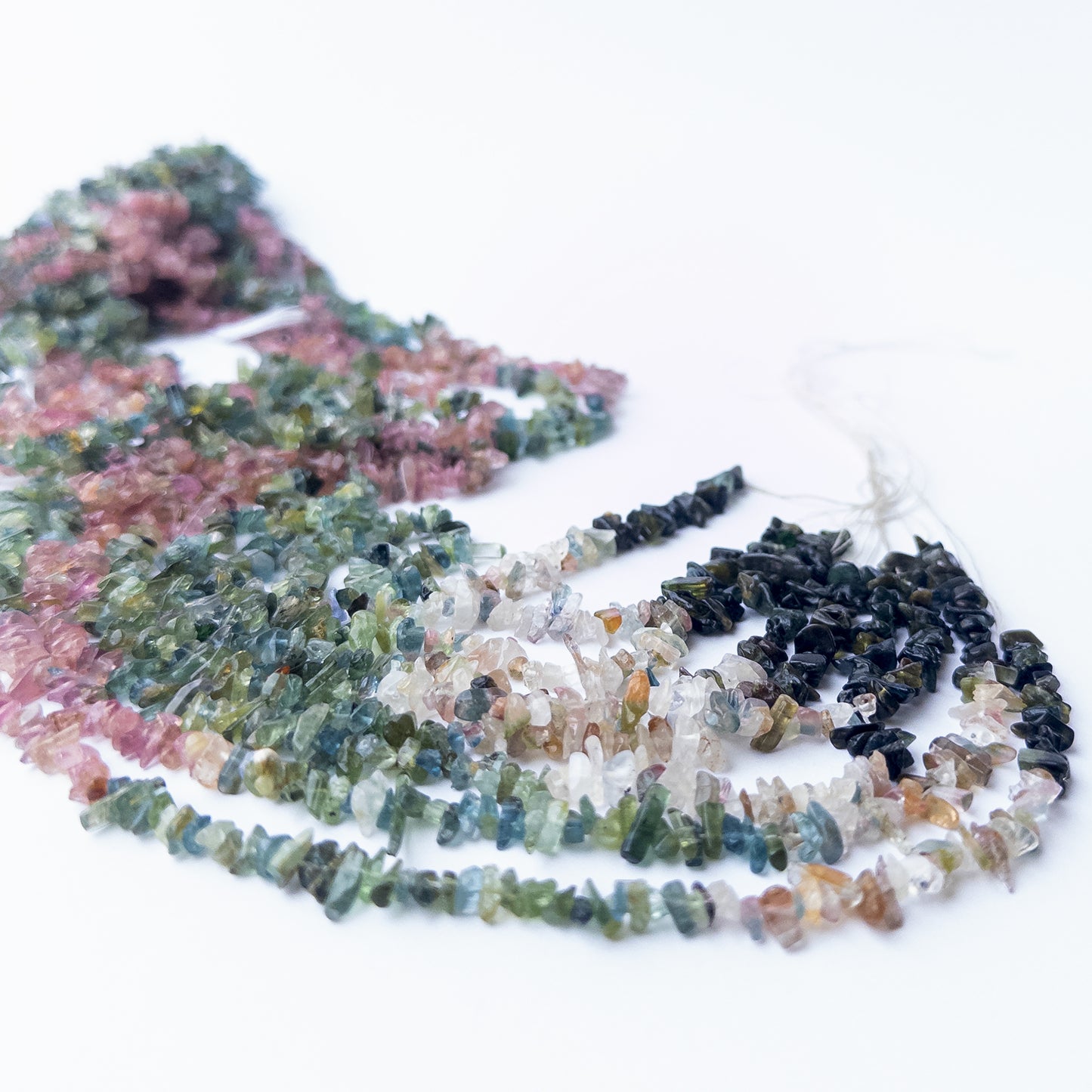 Multi Tourmaline chips arranged neatly, highlighting their colour variety and handcrafted bead quality