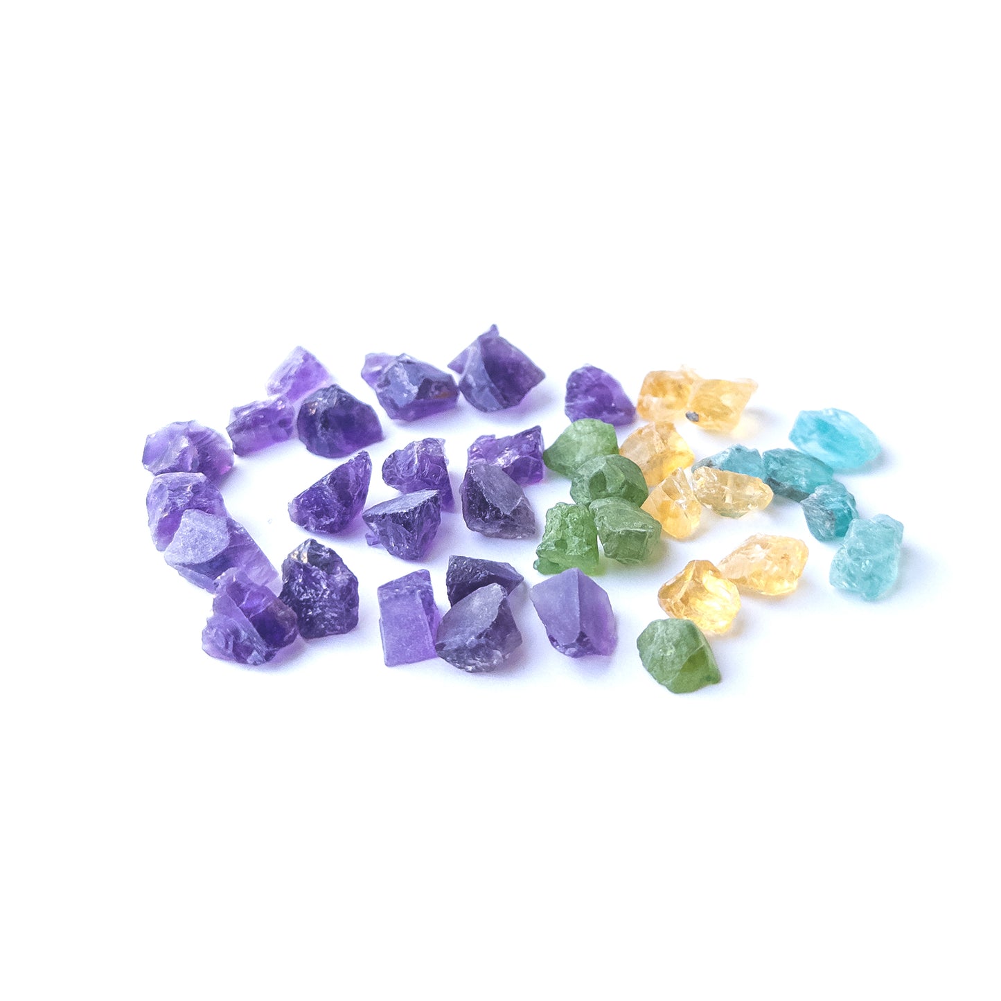 Mixed Amethyst, Citrine, Apatite and Peridot rough stones arranged together with vivid colour contrast.