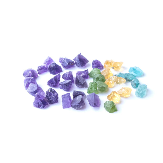 Mixed Amethyst, Citrine, Apatite and Peridot rough stones arranged together with vivid colour contrast.