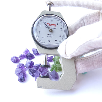 A dial gauge measures the Amethyst, Citrine, Apatite and Peridot rough 7–8mm gemstone.