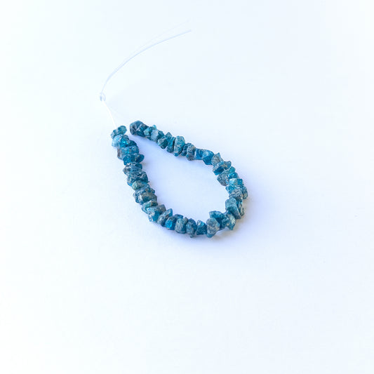 Neon Apatite drilled rough gemstone beads in vibrant blue tones arranged for handmade jewellery components.