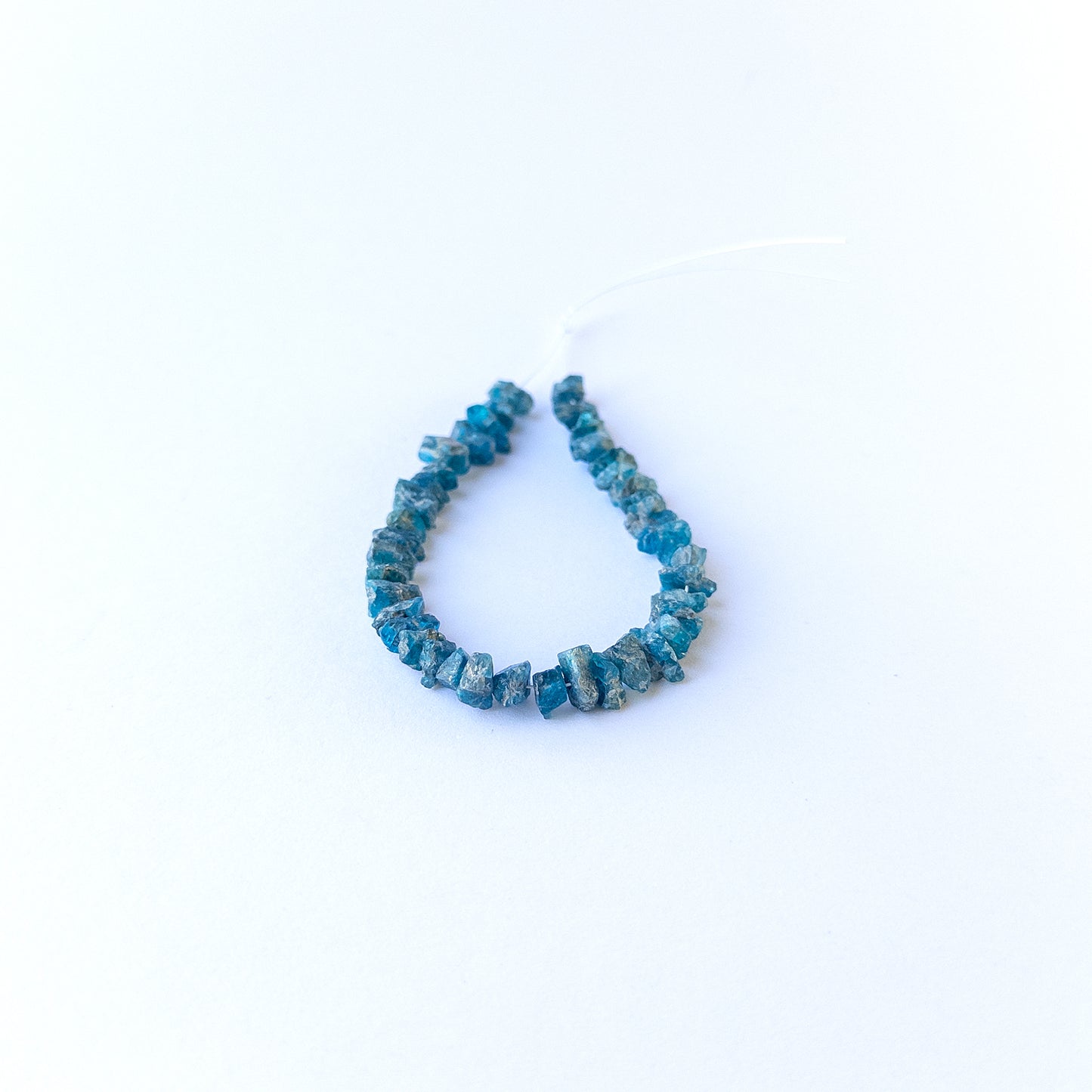 Authentic Neon Apatite rough beads showcasing vivid blue sparkle and organic crystal form.