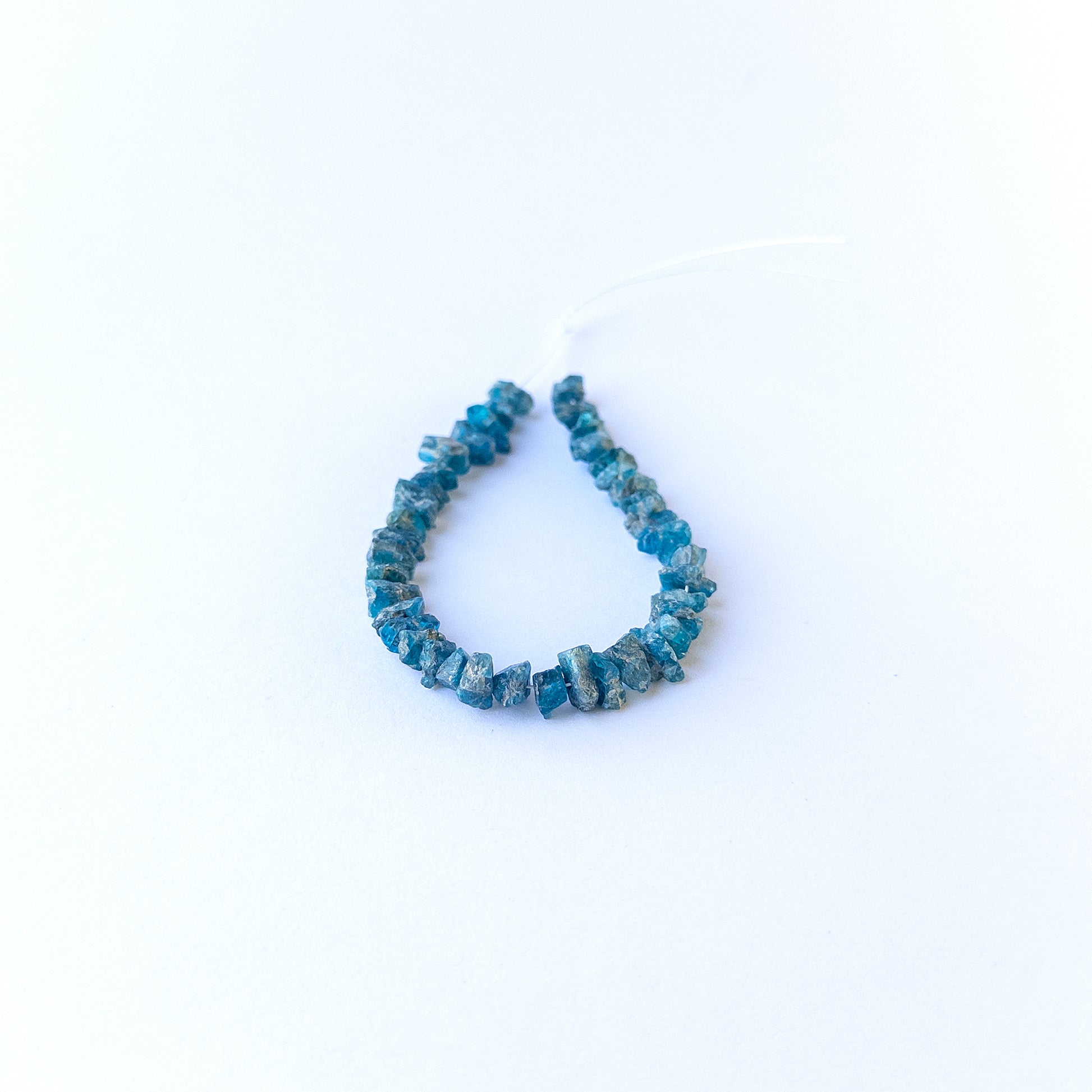 Authentic Neon Apatite rough beads showcasing vivid blue sparkle and organic crystal form.