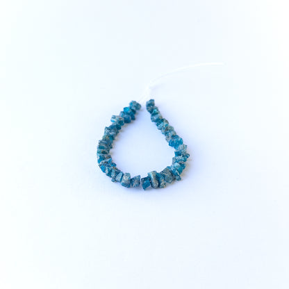 Authentic Neon Apatite rough beads showcasing vivid blue sparkle and organic crystal form.