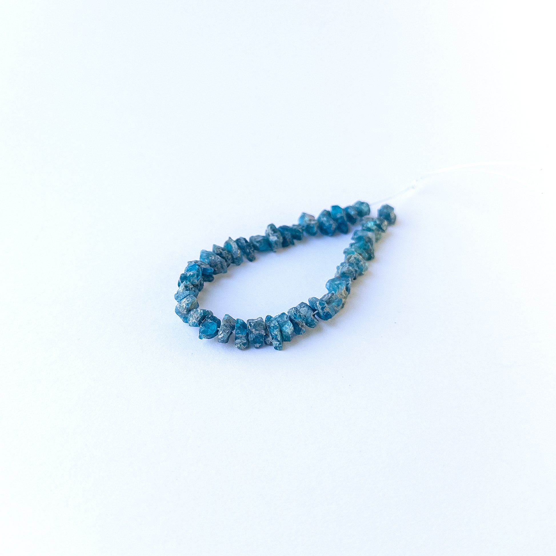 Close‑up of Neon Apatite drilled rough gemstone beads highlighting natural texture and rich colour.