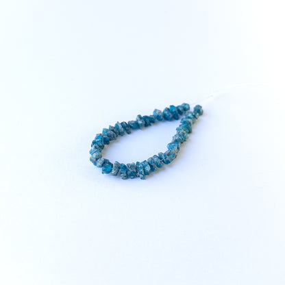 Close‑up of Neon Apatite drilled rough gemstone beads highlighting natural texture and rich colour.
