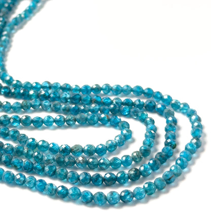 Neon Apatite gemstones in faceted rondelle form, offering strong brilliance and saturated aqua‑blue colouring.