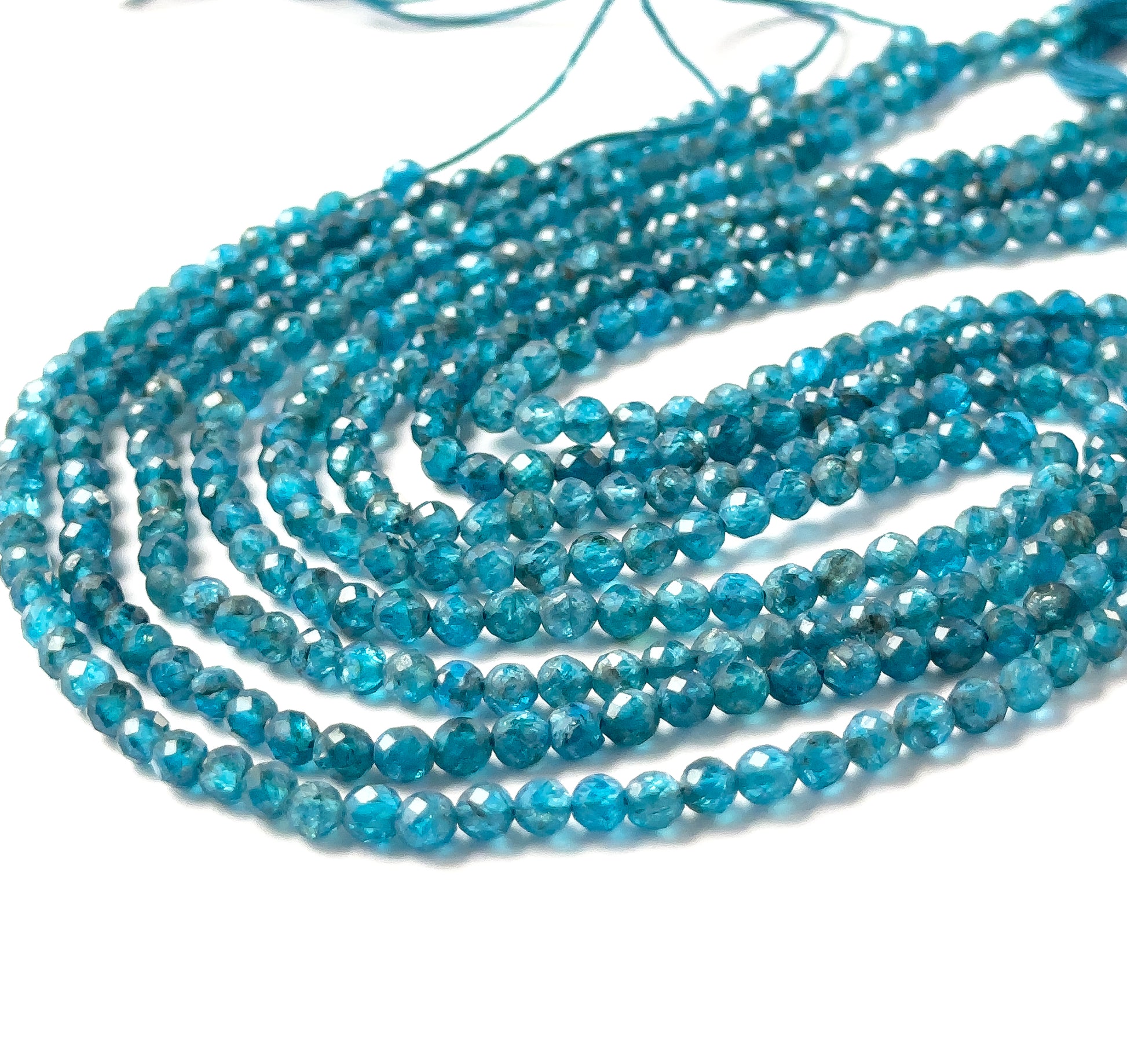 Neon Apatite rondelle beads featuring sharp reflective facets and consistent 3.5–3.7mm sizing.