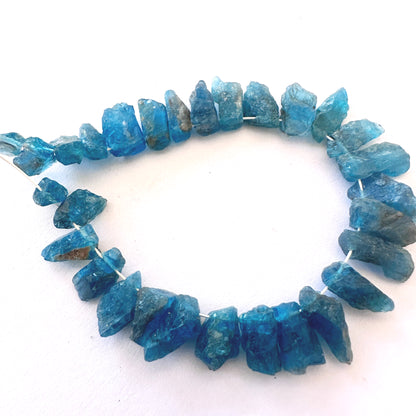 Neon Apatite rough stones with 0.5mm bead holes, ideal for secure stringing and bold jewellery.