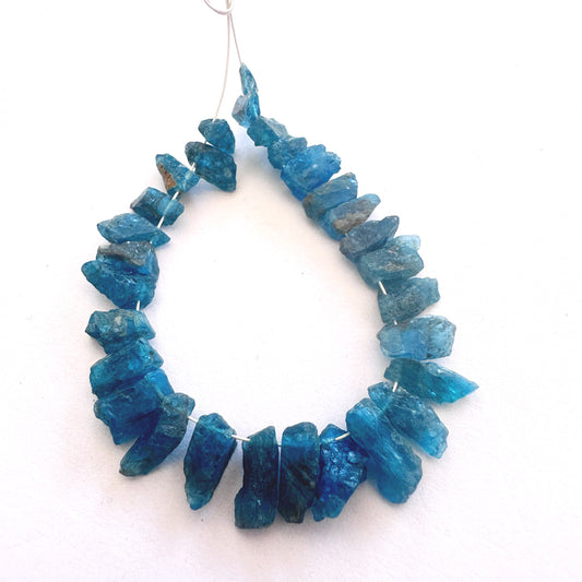 Neon Apatite rough beads with vivid blue colour and side-drilled 4–5mm size.