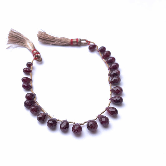 Red Ruby Beaded string with tassel on a white background.