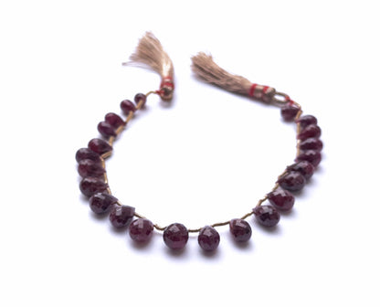 Ruby faceted teardrop beads arranged in a neat strand with rich red colour.

