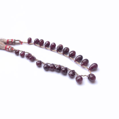Stone beads in ruby with faceted surfaces highlighting shine and clarity.