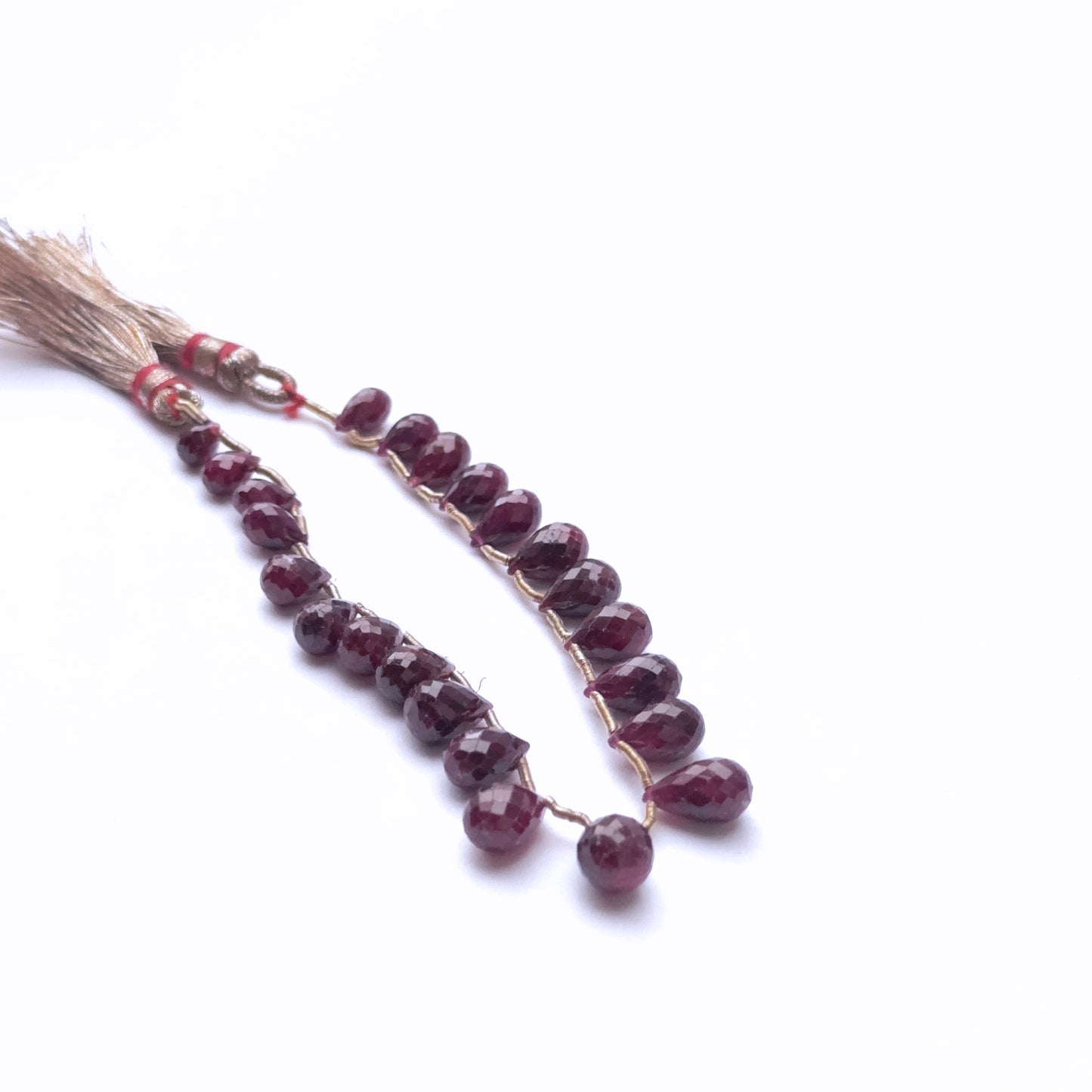 Handmade jewellery components featuring ruby teardrops in vibrant tones.