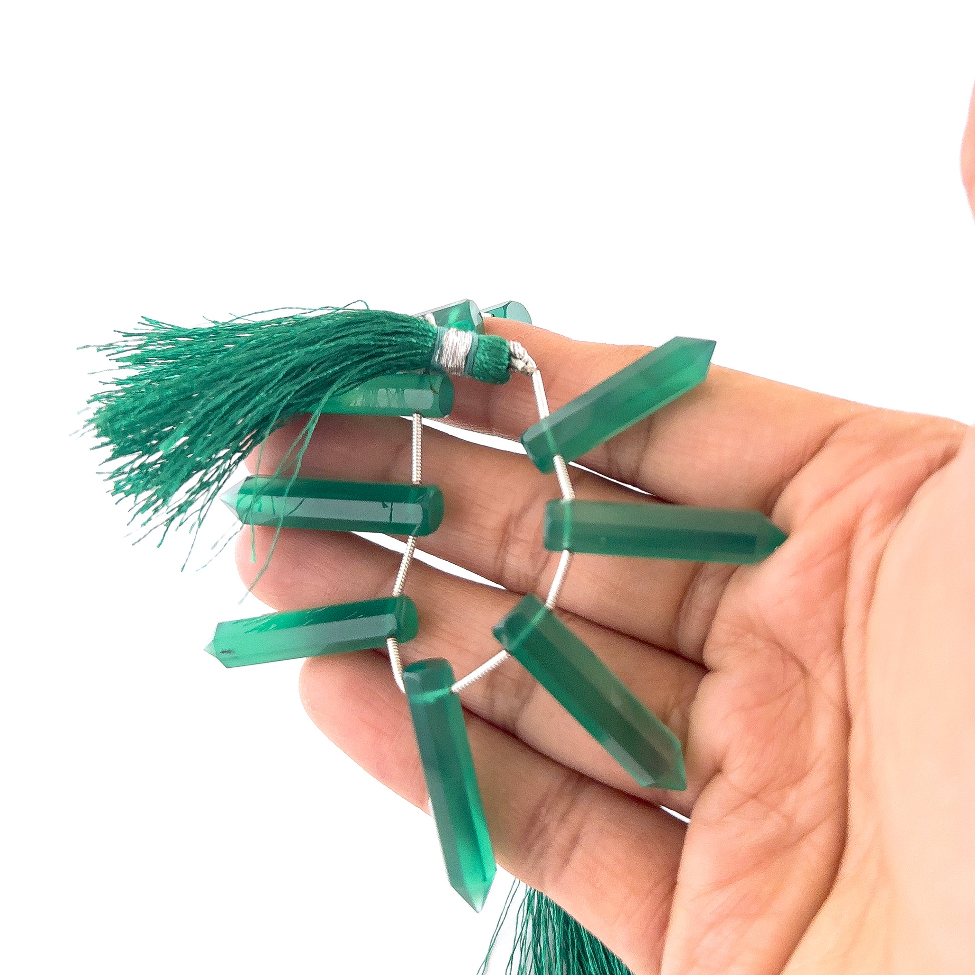 Green Onyx gemstones in faceted pencil briolette form, offering bright reflective shine and elegant elongated shaping.