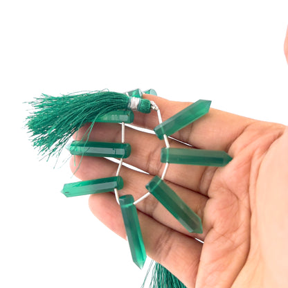 Green Onyx gemstones in faceted pencil briolette form, offering bright reflective shine and elegant elongated shaping.