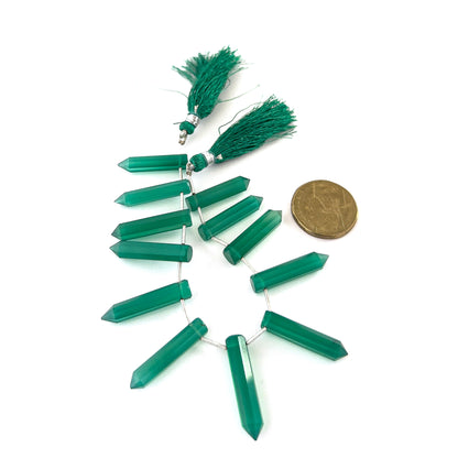 Green Onyx faceted pencil briolettes with glossy surfaces and consistent shaping in a 12‑piece selection.