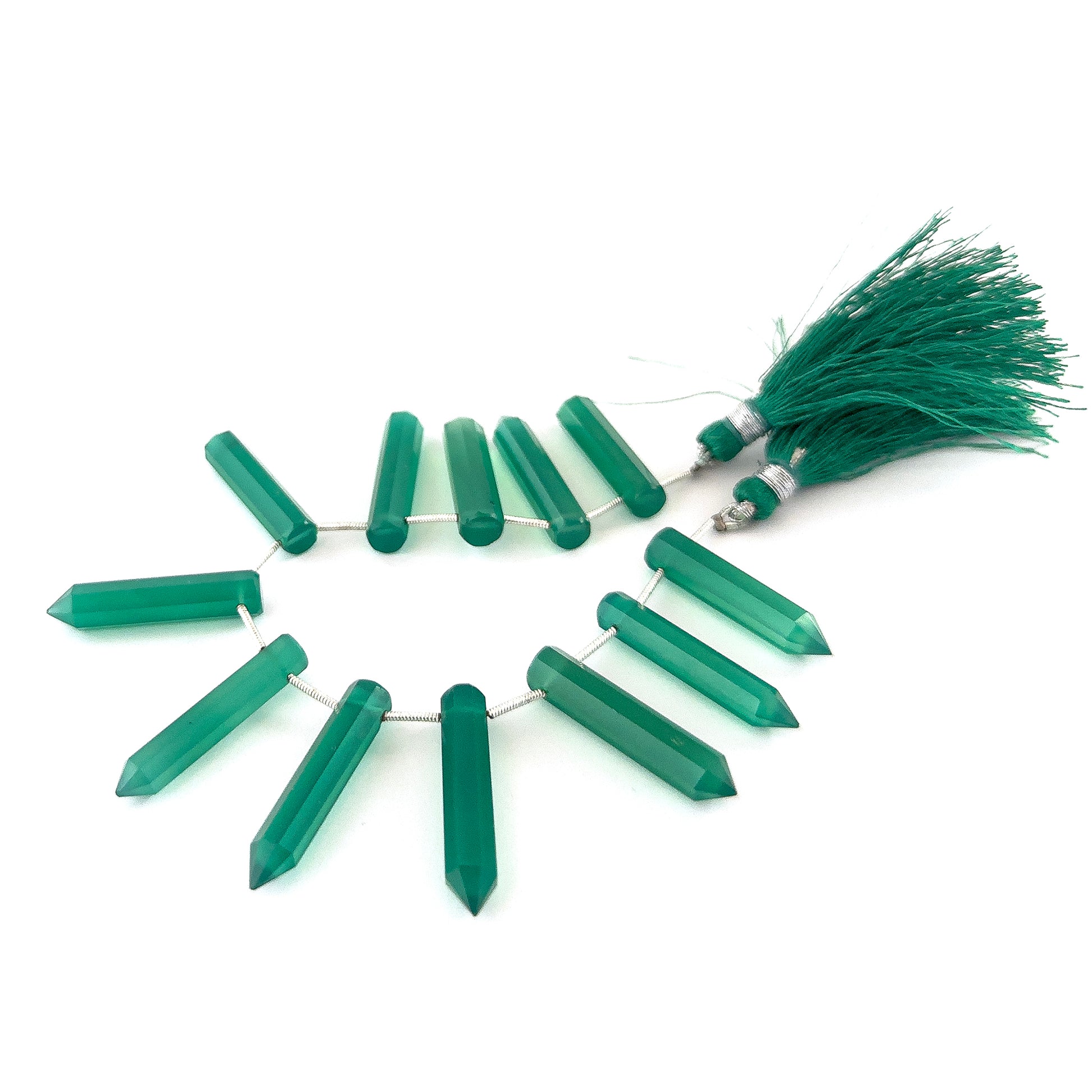 Close‑up of Green Onyx faceted pencil briolette beads highlighting their reflective facets and vibrant green hue.