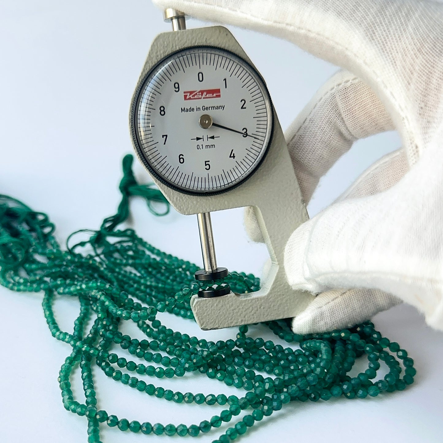 A dial gauge measures the Onyx faceted rondelle 3.1mm gemstone.