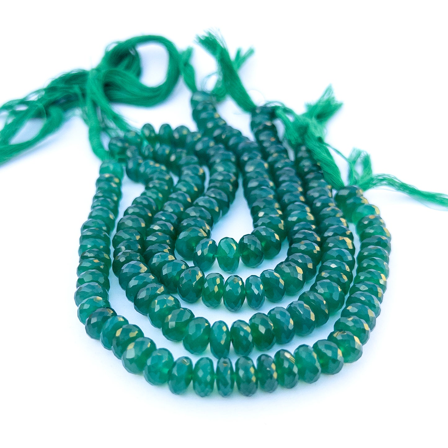 Close‑up of genuine green onyx faceted rondelle gemstone beads with bold colour for DIY jewellery making.