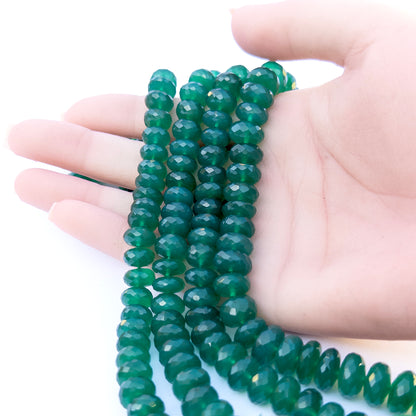 A person holds delicate strands of Green Onyx beads, showcasing their Faceted Rondelle design.