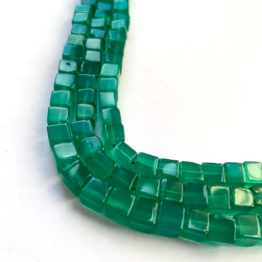 Onyx Smooth Cube gemstone beads arranged on a 21cm strand, neatly aligned for jewellery making.