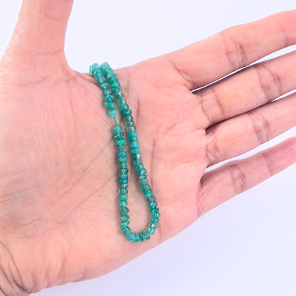 A person holds delicate strands of Onyx beads, showcasing their smooth design.