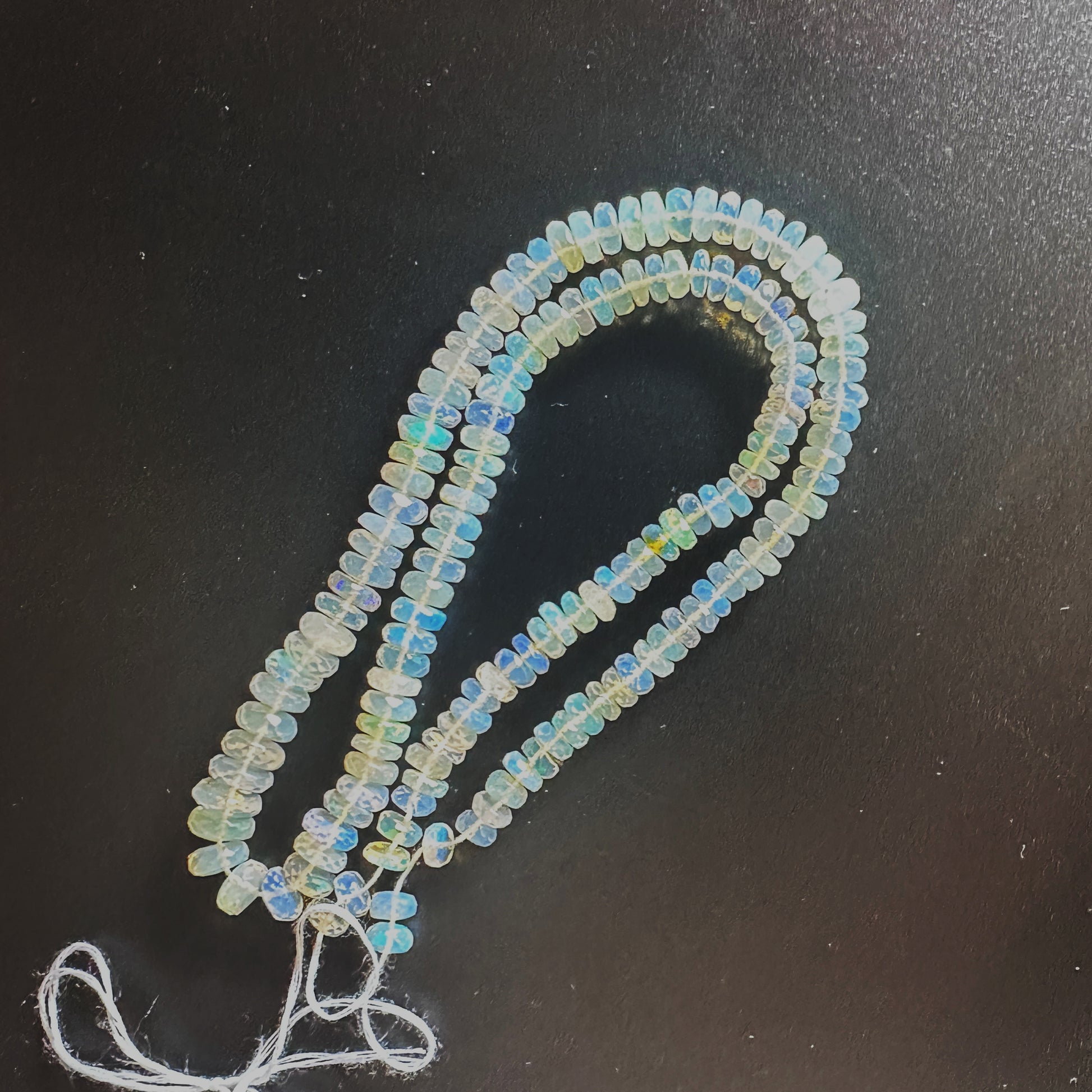 Close-up of 5.5-7.0mm Opal beads showing faceted surfaces and vibrant hues.