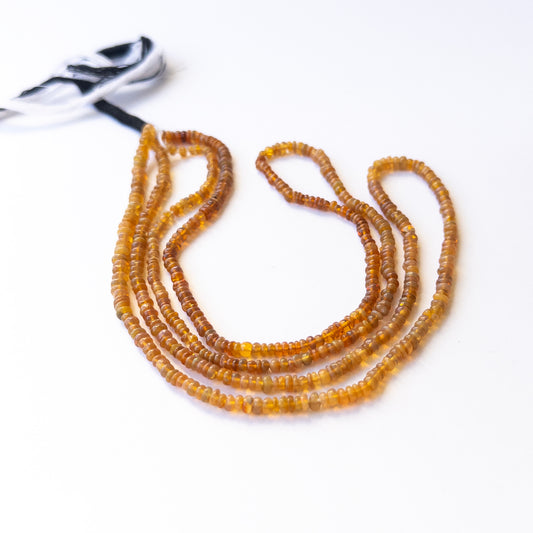 Premium Opal gemstone beads in smooth rondelle cut arranged in strands, showcasing subtle fire for jewellery designers.
