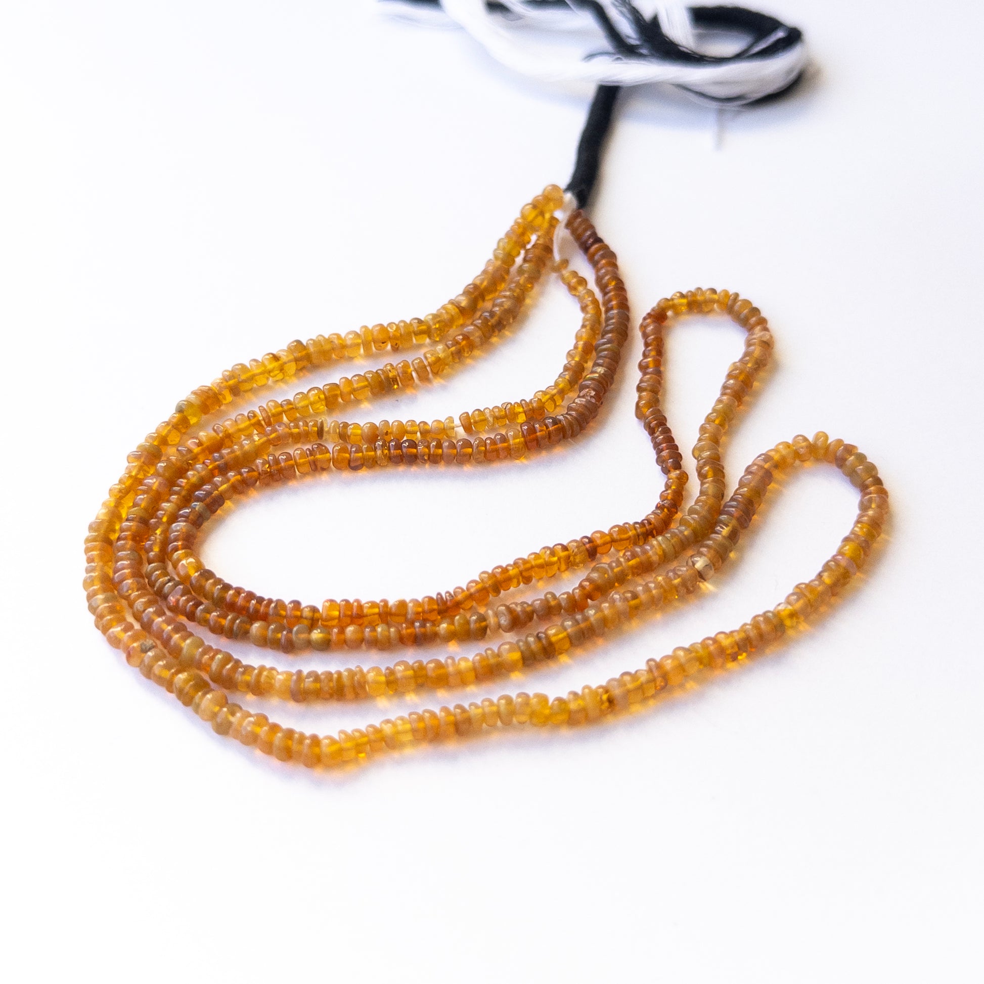 Close‑up of authentic Opal smooth rondelle stone beads highlighting natural colour play and quality for DIY jewellery making.