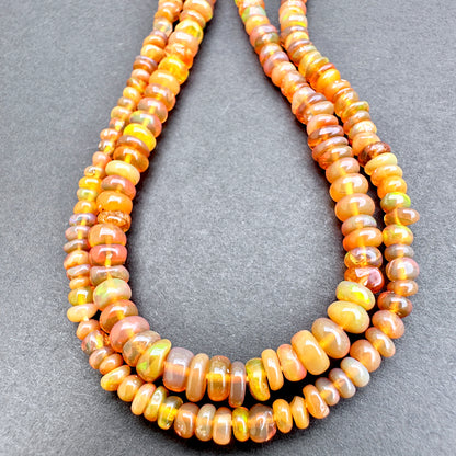 Opal with orange and yellow beads on a gray background.
