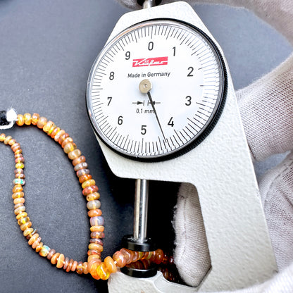 Dial gauge measure opal beads.