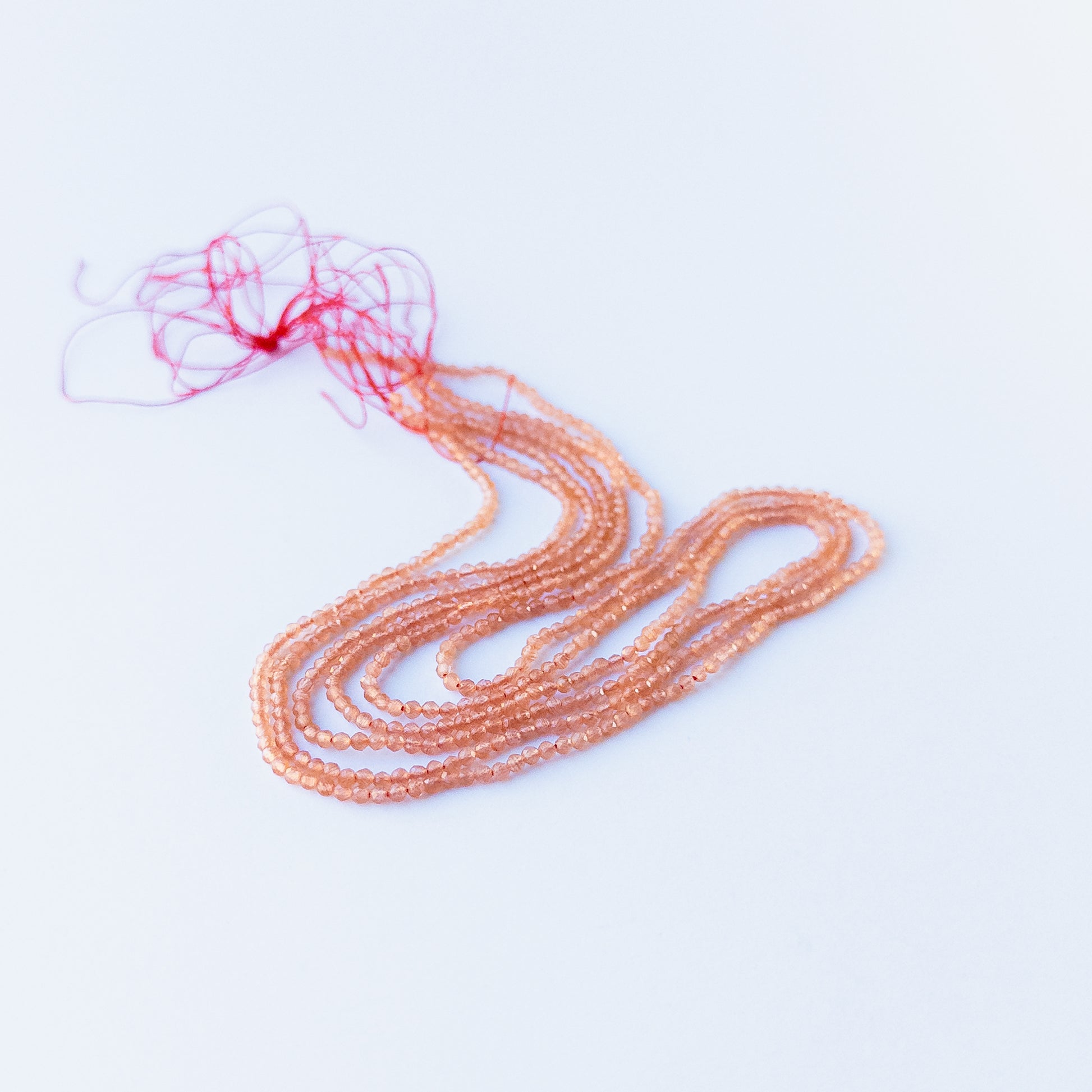 Close‑up of genuine Orange Chalcedony faceted rondelle beads showing their shine, clarity, and delicate 2.2mm cut.
