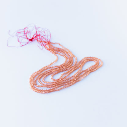 Close‑up of genuine Orange Chalcedony faceted rondelle beads showing their shine, clarity, and delicate 2.2mm cut.