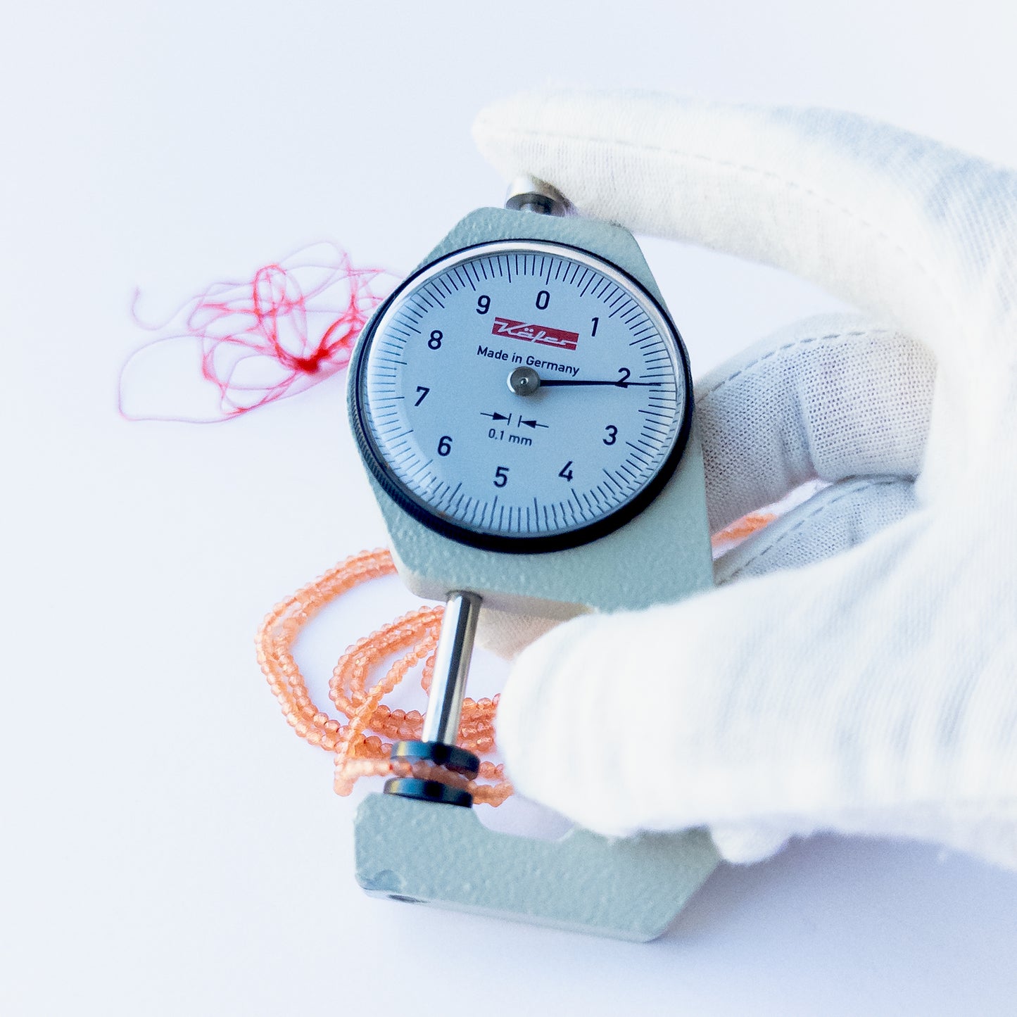 A dial gauge measures the Orange Chalcedony faceted rondelle 2.2mm gemstone.