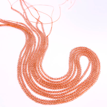 Orange Quartz gemstone beads for jewellery making displayed with soft lighting.