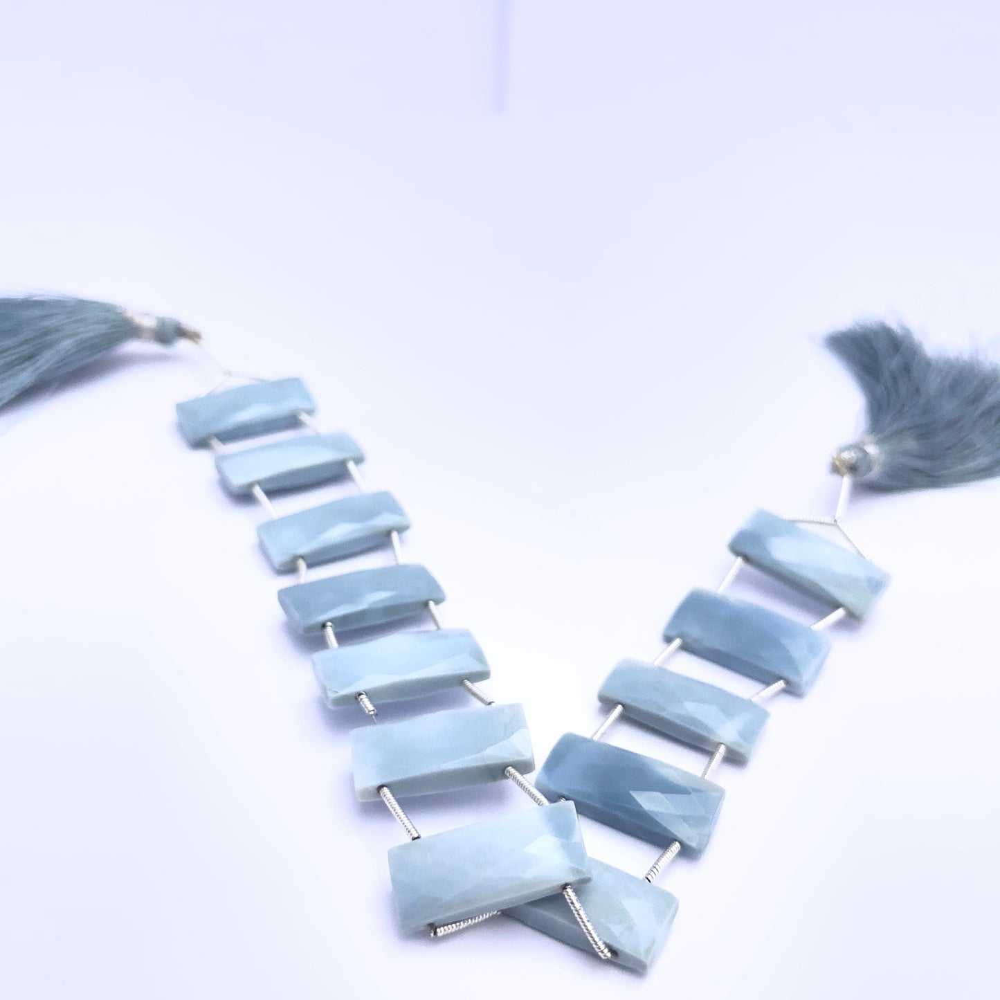 Owyhee Opal gemstone beads for jewellery making displayed with soft lighting.