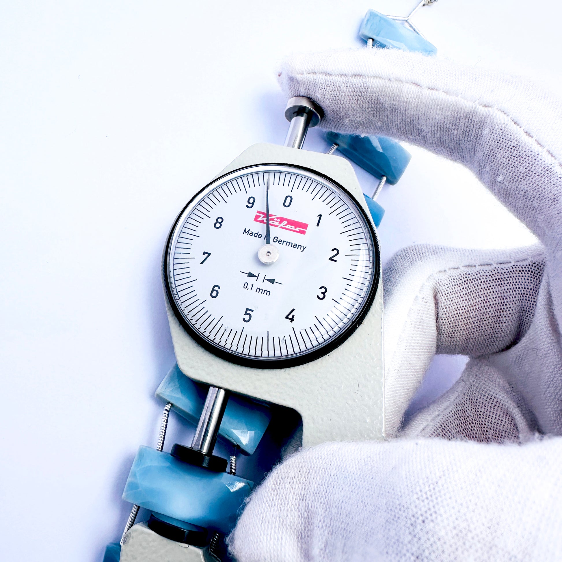 A dial gauge measures the Owyhee Opal faceted rectangle 21×9mm gemstone.